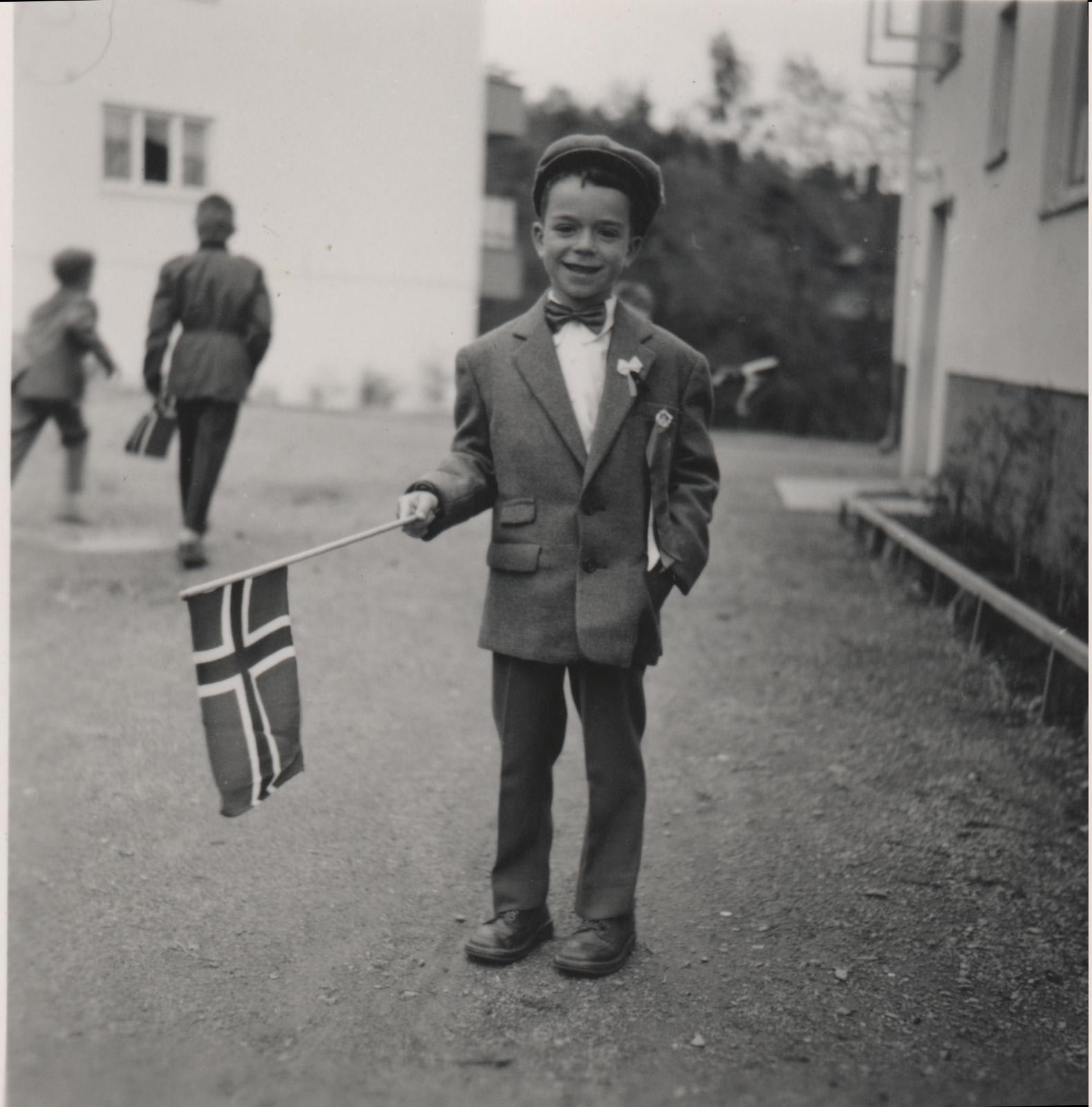 Jan Kjærstad på 17. mai (1960) utenfor blokken i Hagelundveien der han vokste opp, rett ved «skråningen». Han begynte i 1. klasse samme høst. Foto: privat